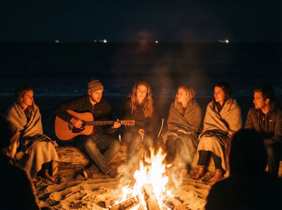 A group of six friends around a bonfire on a beach at night