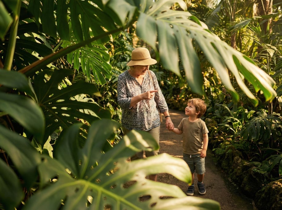A grandmother and grandchild walking through a botanical garden