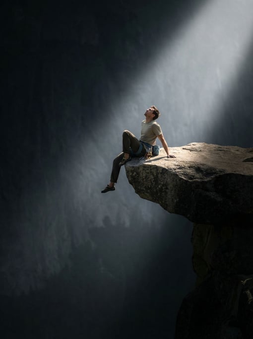 A rock climber resting on a narrow ledge, legs dangling, vast cliff face below, morning mist (ck8oiuvl)