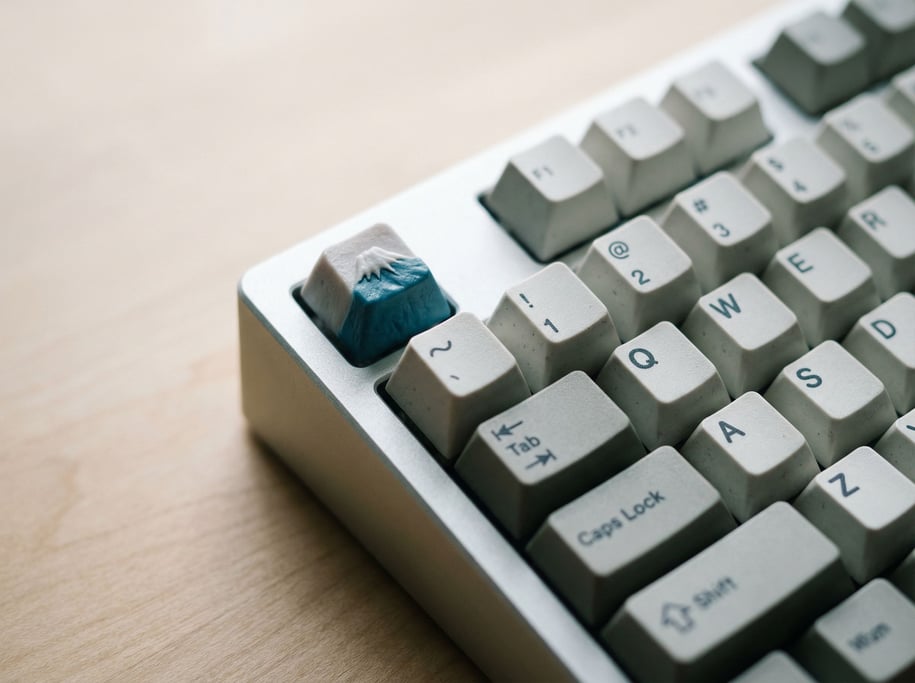 A mechanical keyboard with custom keycaps, macro view showing surface texture and legends (5cuktlz)