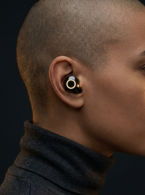 A person in profile — one concept translation earbud visible in the near ear