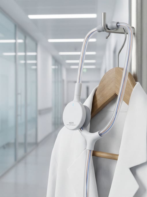 A concept digital stethoscope in matte white medical polymer with a flat disc-shaped chest piece housing a MEMS microphone array