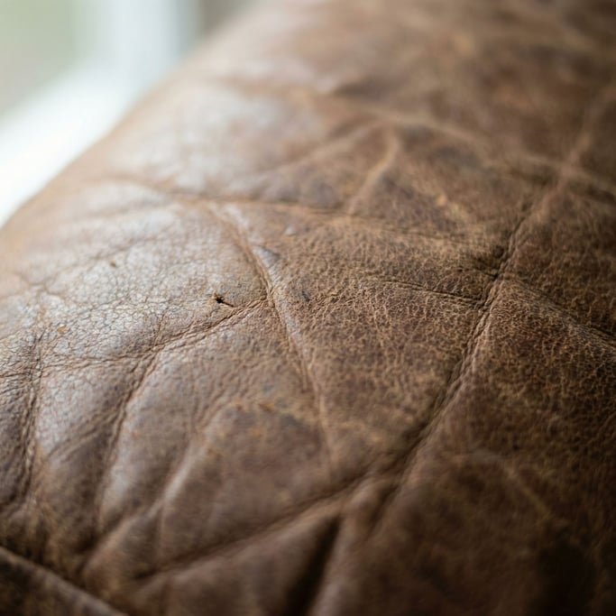 Extreme close-up of Worn leather surface showing natural grain, scratches