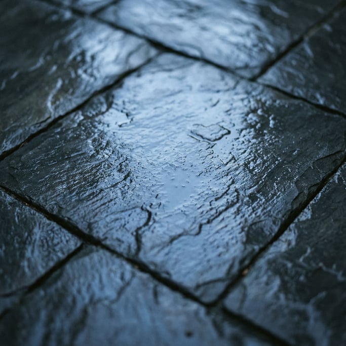 Wet dark slate tiles, reflective surface with cool blue undertones