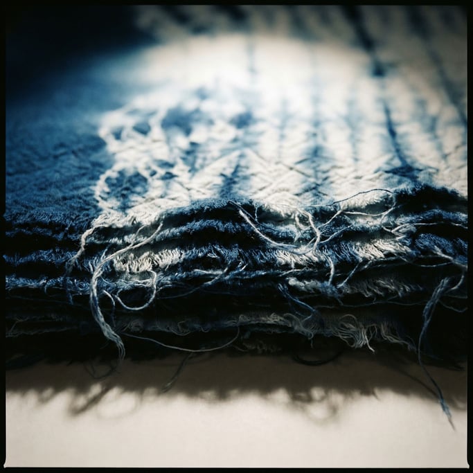 Shibori-dyed indigo fabric, resist patterns creating organic white shapes on deep blue (qodgxjup)