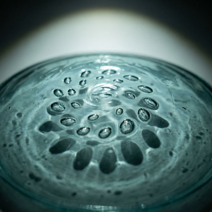 Handblown glass with trapped air bubbles in a spiral pattern, aquamarine tint