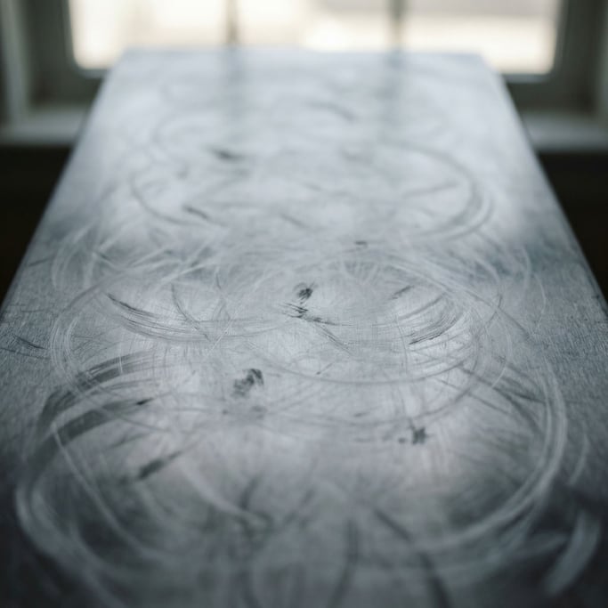 Brushed stainless steel with circular polishing marks, cool industrial surface