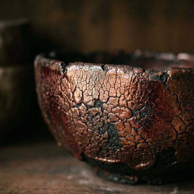 Detail photograph of Ceramic raku glaze, metallic copper reduction over black clay body