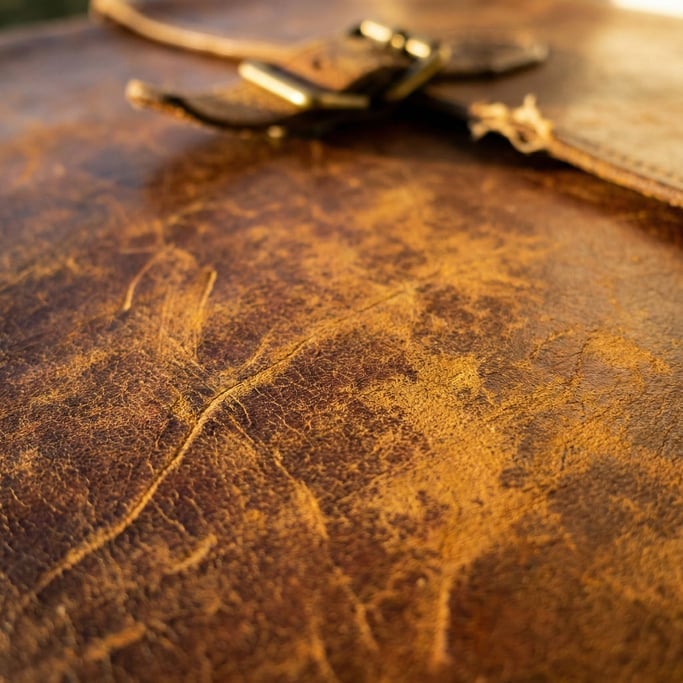 Worn leather surface showing natural grain, scratches, and patina from years of use