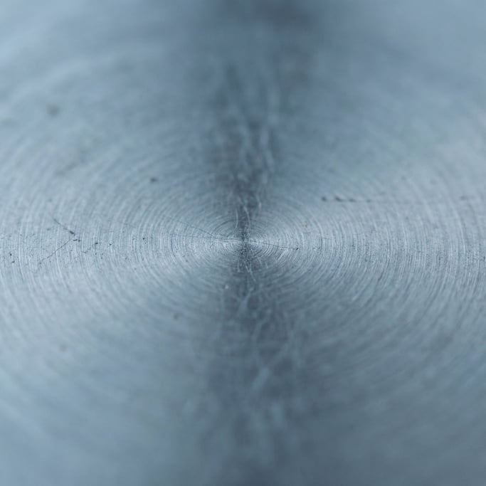 Brushed stainless steel with circular polishing marks, cool industrial surface (berrvqco)