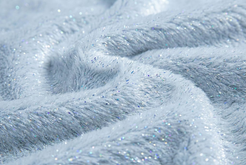 Ice-white synthetic fur with holographic micro-shimmer filling the frame in ruffled peaks