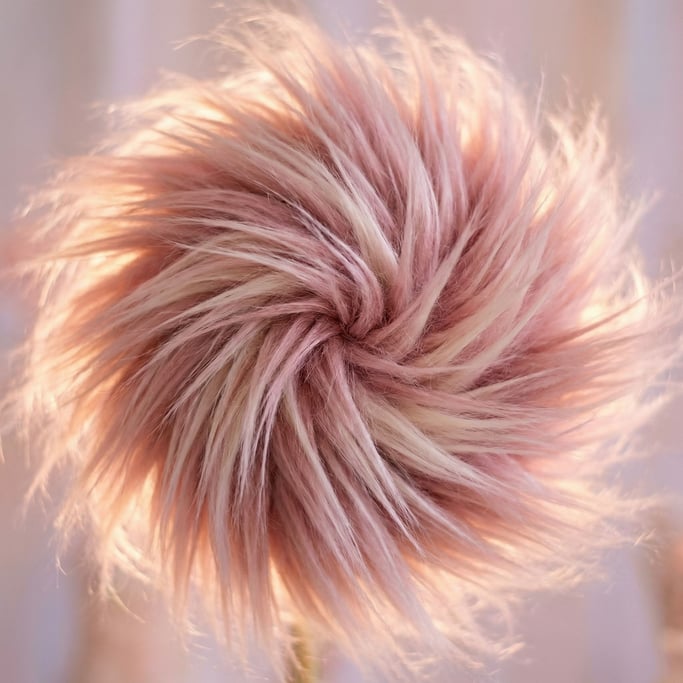 Blush-pink faux fur in long flowing strands arranged in a radial pattern emanating from the center