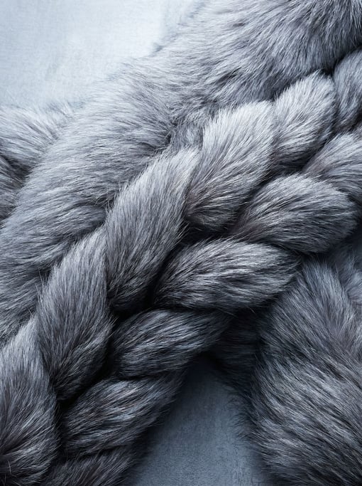 Platinum-silver long-haired fur flowing in thick braided-looking ropes across the surface diagonally