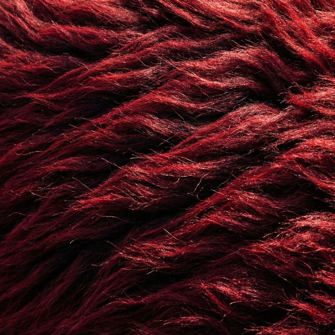 Oxblood-red yak fur in thick matted waves flowing diagonally from upper left to lower right
