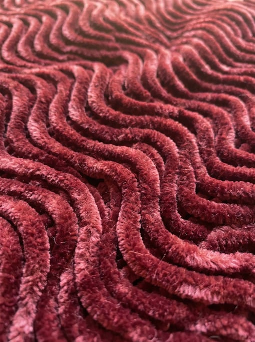 Bordeaux chenille in thick twisted yarn dominating the composition in dense S-curve waves