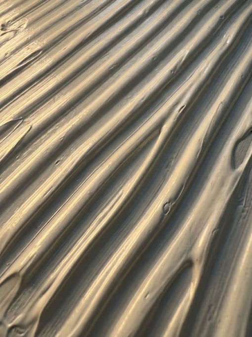 Titanium white oil paint applied in thick parallel ridges with a notched squeegee captured at macro