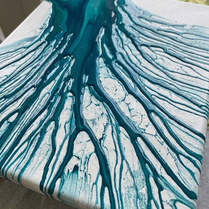 Phthalo turquoise acrylic paint poured in thin rivulets over a tilted surface stretching edge to edg