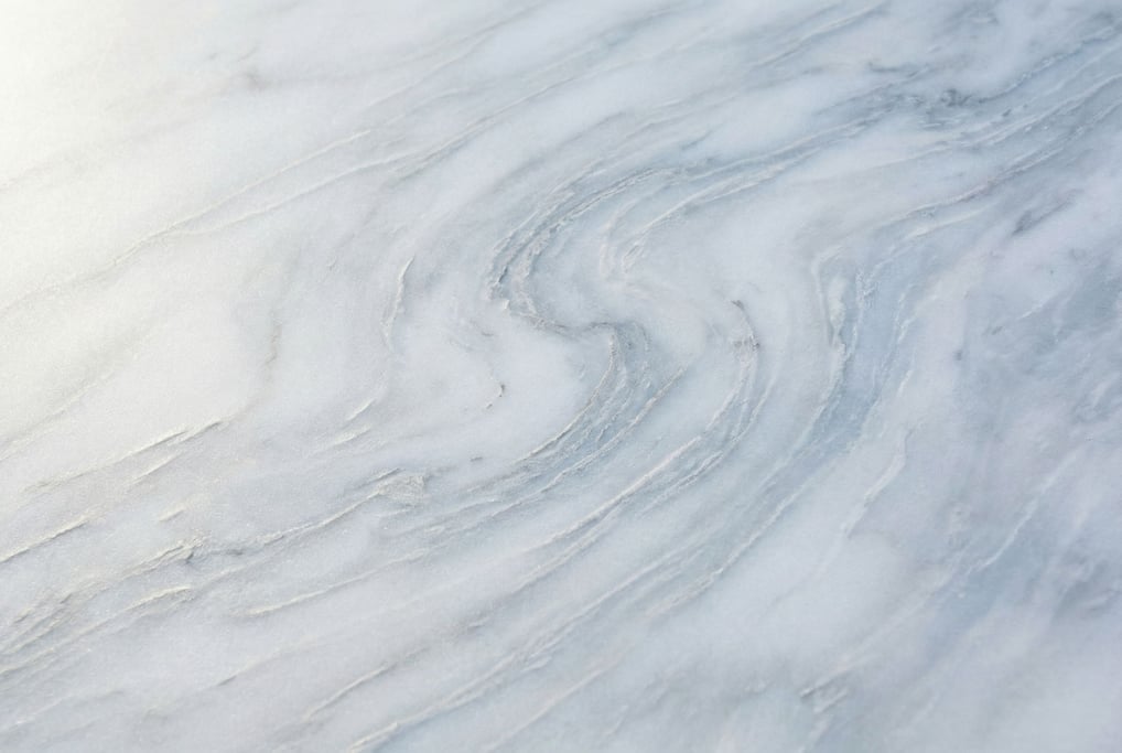 Carrara marble in extreme close-up filling the frame with its cloud-like grey veins threading throug