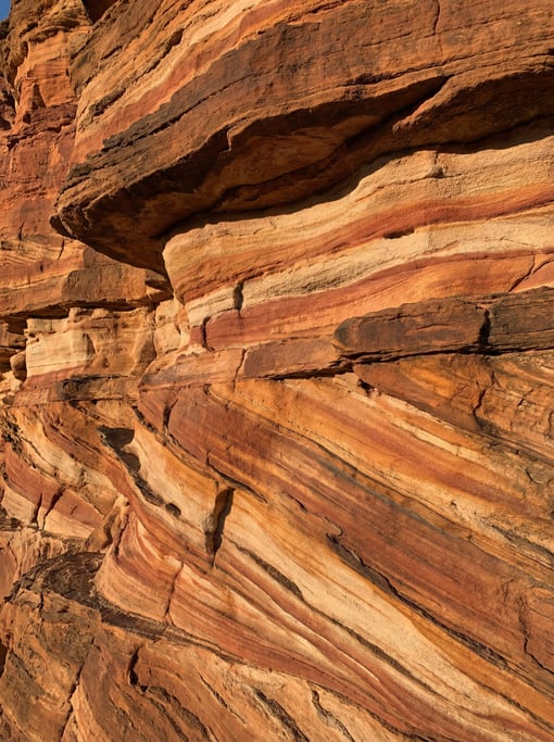 Rusted iron-rich sandstone layers exposed in cross-section consuming the entire view