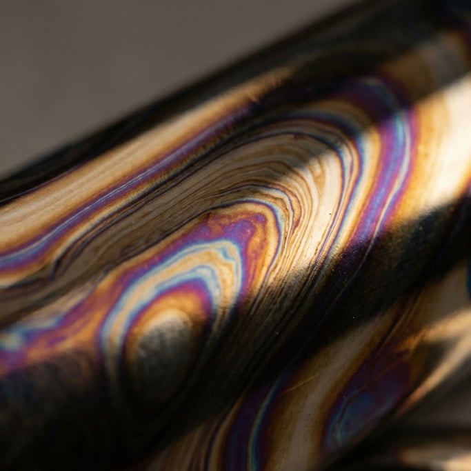 Anodized titanium showing heat-temper colors captured at macro scale