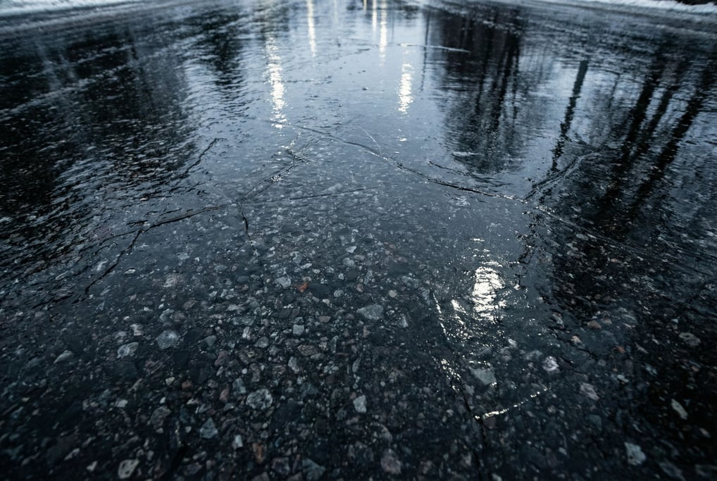 Black ice on asphalt filling the frame
