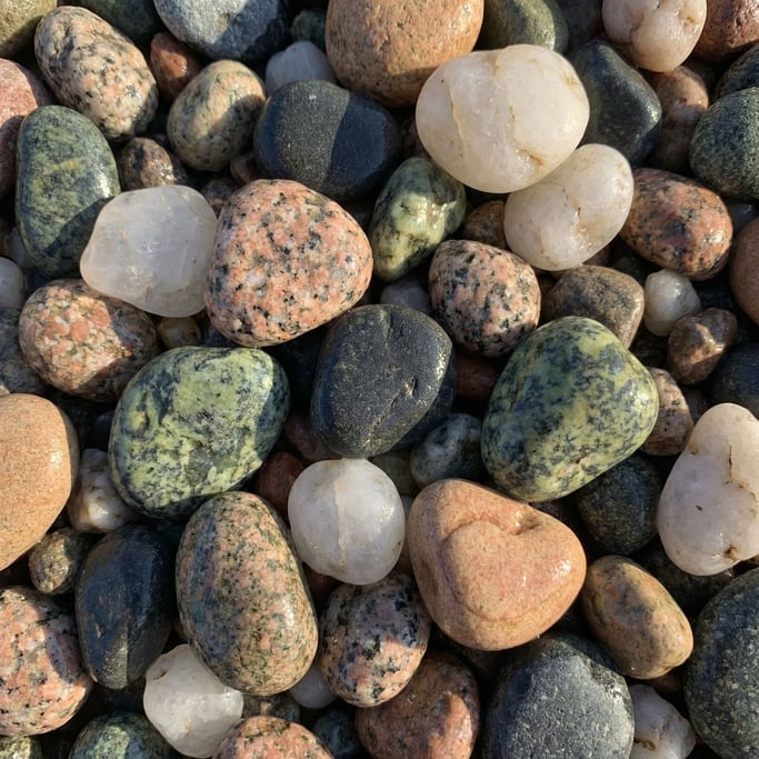 Mixed river gravel seen in extreme close-up with rounded stones of every color and type