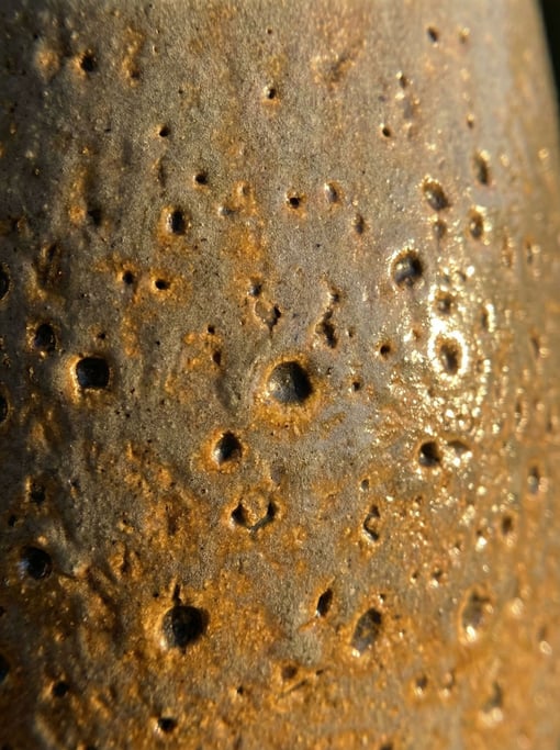 Salt-glazed stoneware surface captured at macro scale with its characteristic orange-peel texture