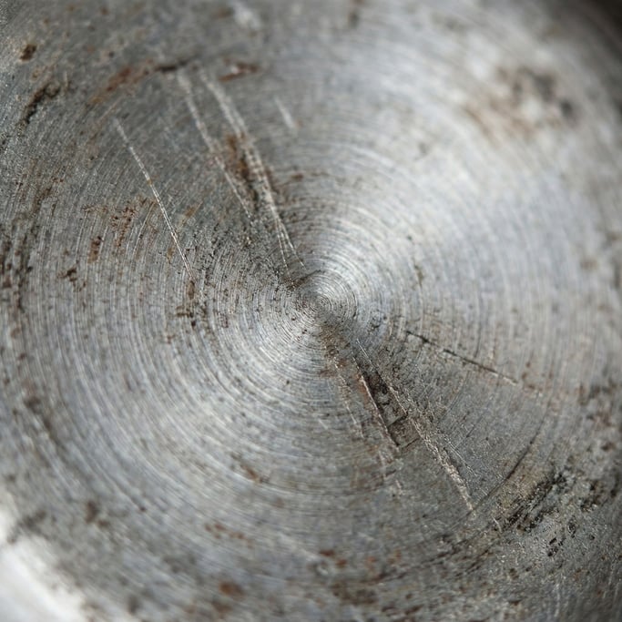 Extreme close-up of Brushed stainless steel with circular polishing marks, cool industrial surface