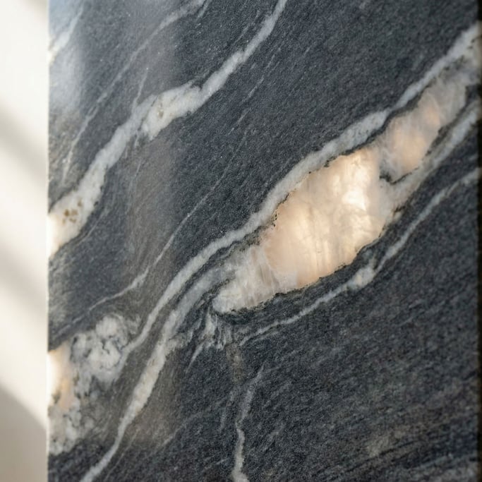 Extreme close-up of Polished dark granite with veins of white quartz running through, cool and heavy (p7lxiix5)