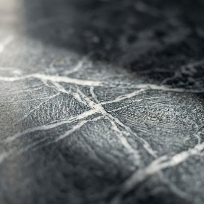 Extreme close-up of Polished dark granite with veins of white quartz running through, cool and heavy