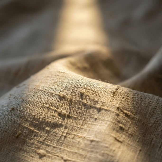 Extreme close-up of Raw silk fabric draped and catching side light (tw6tqhxv)