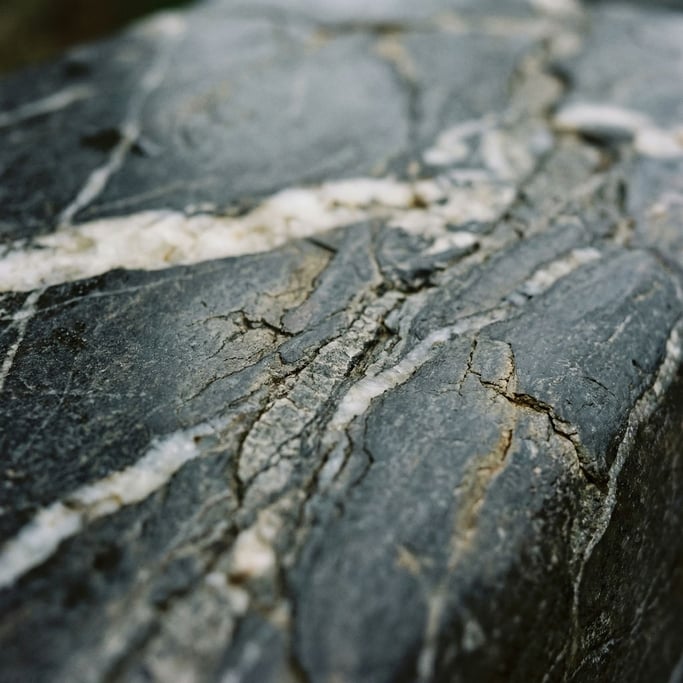 Extreme close-up of Polished dark granite with veins of white quartz running through, cool and heavy (y4tt)