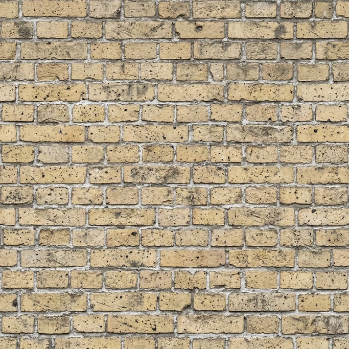 Seamless tileable texture of yellow London stock brick heavily worn and patinated