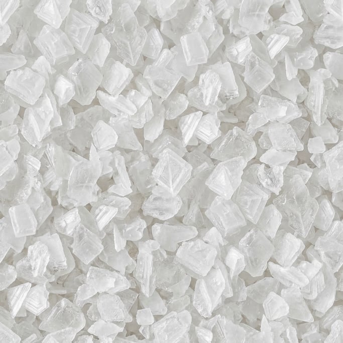 Seamless tileable texture of coarse sea salt in extreme close-up showing micro-detail