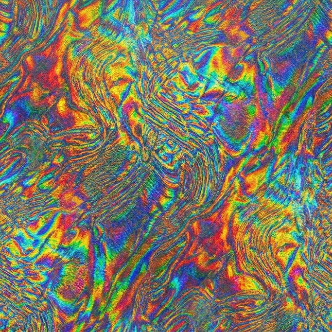 Seamless tileable texture of holographic foil in extreme close-up showing micro-detail