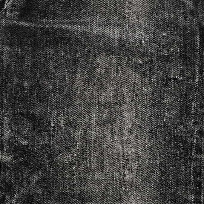 Seamless tileable texture of black denim heavily worn and patinated