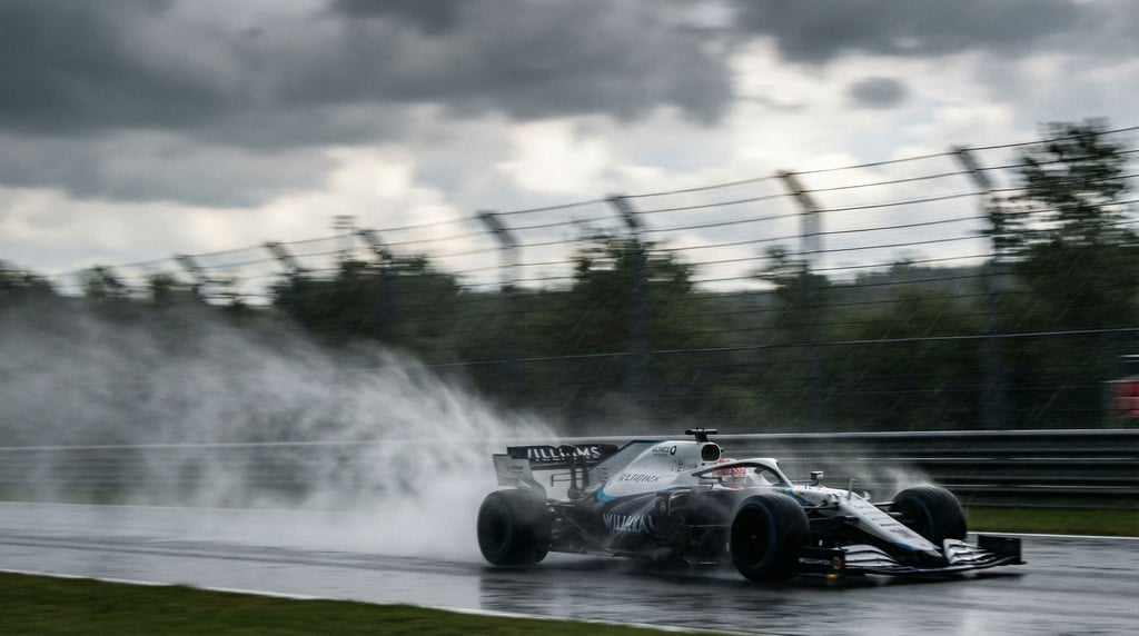 Open-wheel race car at speed on a wet circuit, rooster tail of spray behind it