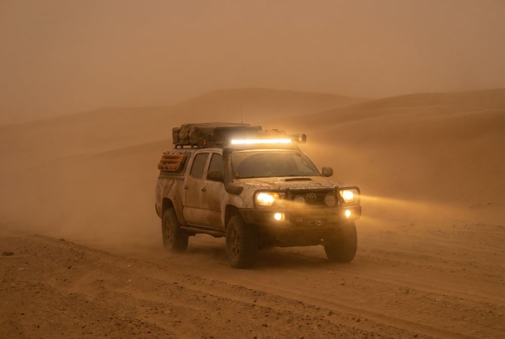 Four-wheel-drive truck on a dusty trail in a sandstorm, visibility reduced to fifty meters