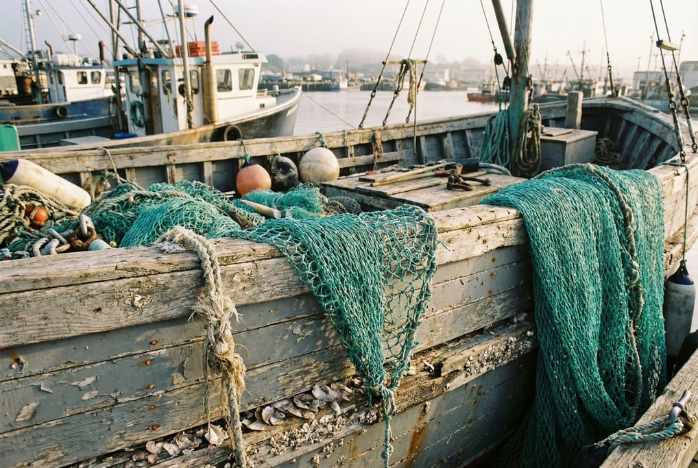 Fishing nets draped over the gunwale of a wooden trawler