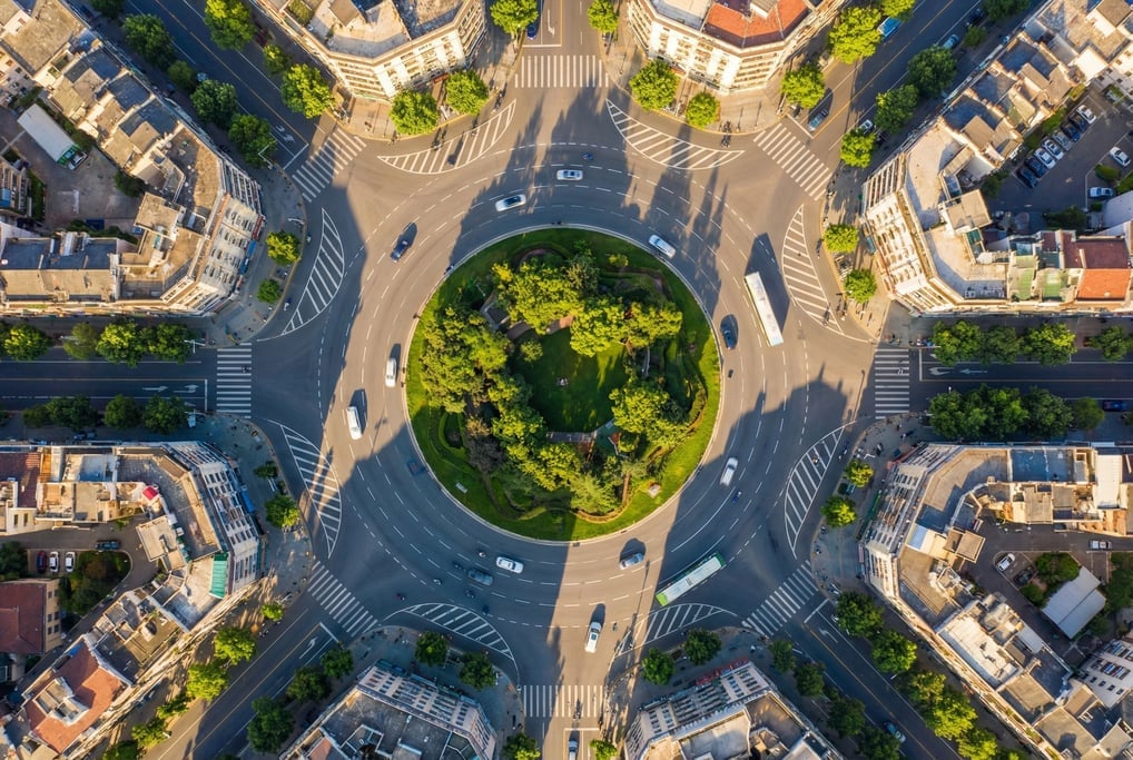 Overhead drone shot of a roundabout with vehicles in motion
