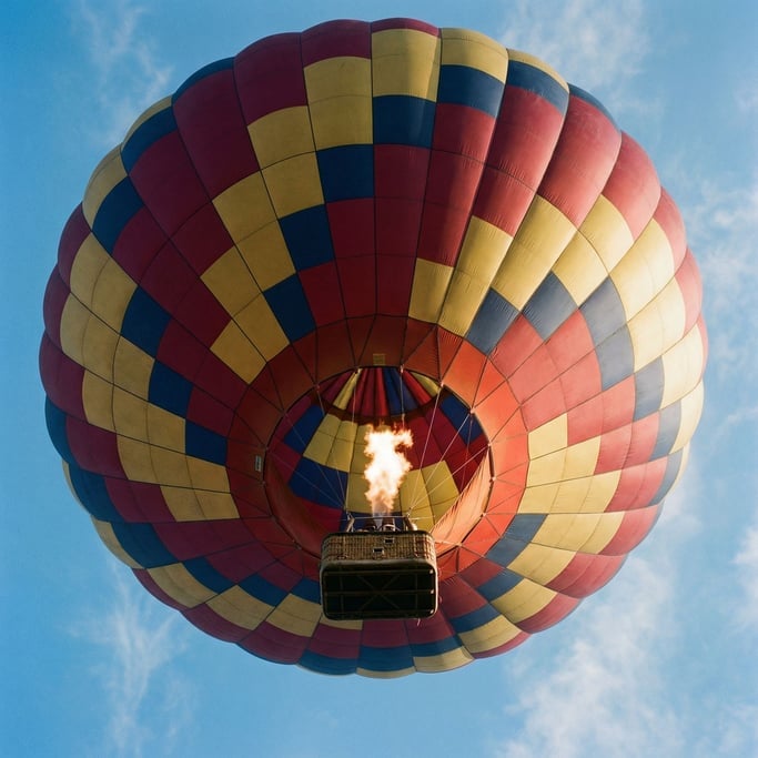 Hot air balloon canopy from directly below looking up, the geometric panels of red, gold