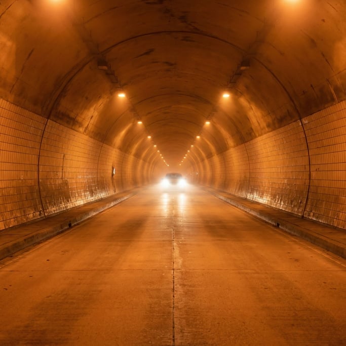 Tunnel interior with a single car's headlights approaching