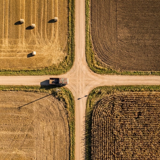 Overhead view of a crossroads in a rural area, dirt roads meeting at right angles