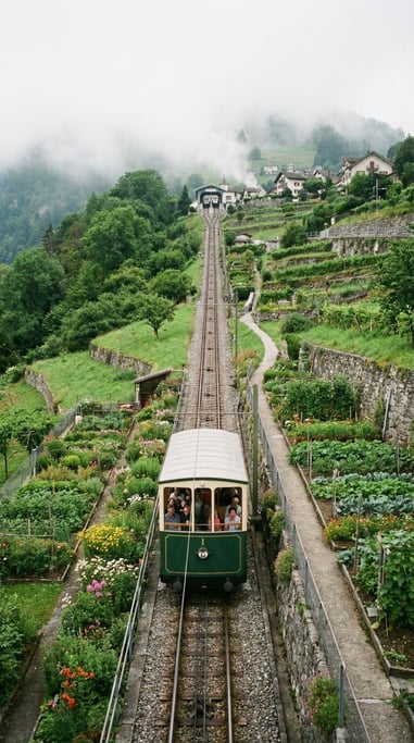Funicular railway car ascending a steep green hillside