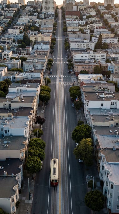 Aerial view of a tram on tracks running straight toward the viewer, shot from above and ahead
