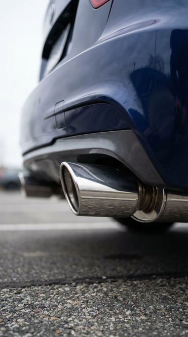Car exhaust pipe from ground level, the chrome tailpipe filling the lower frame