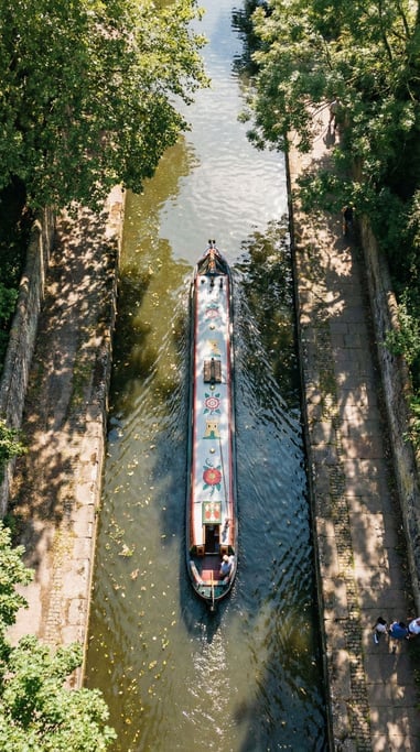 Drone shot looking straight down at a canal with a narrow boat