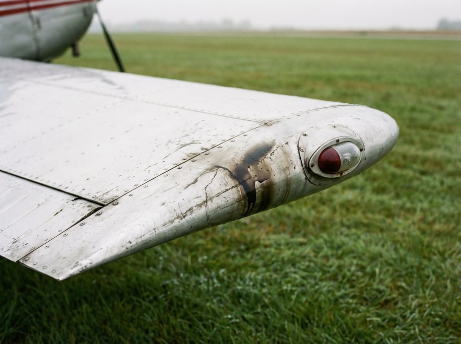 Wing tip of a small aircraft on the ground, the navigation light at the end