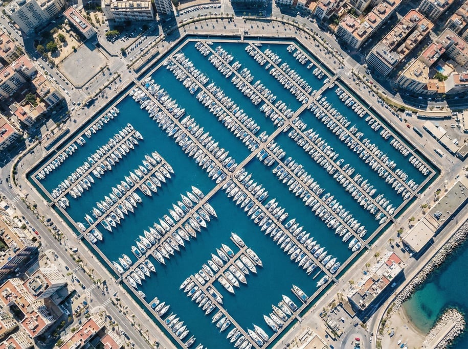 Aerial view of a harbor with boats in organized slips creating a geometric grid pattern