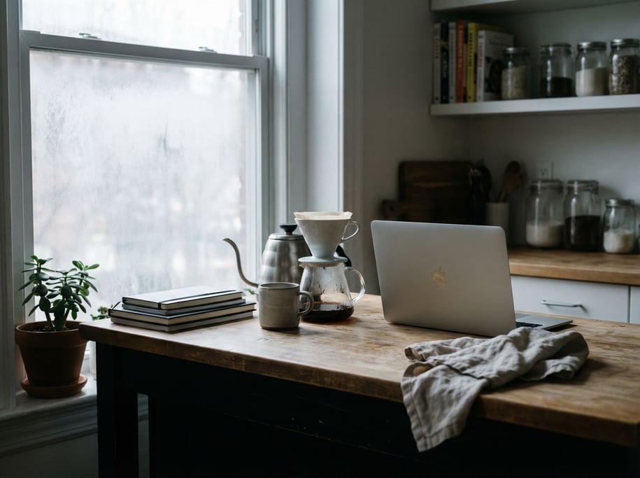A clean minimal desk with a single laptop and ceramic coffee mug (de)